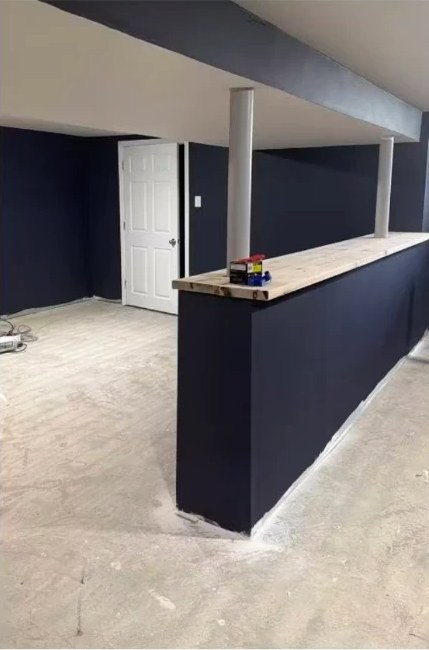 After interior painting: navy-blue basement bar half-wall and walls