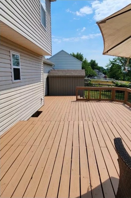 After deck staining: tan-stained deck boards and railing