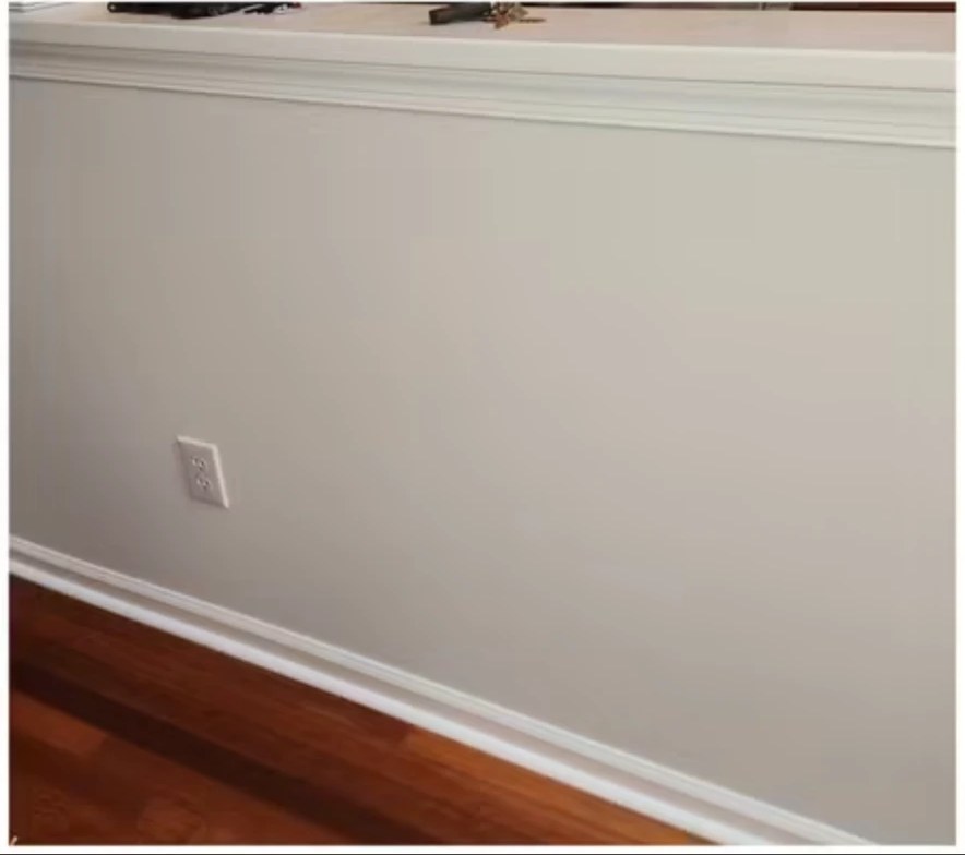 After interior painting: light gray wall below a half wall with crown molding